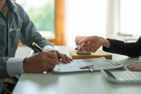 Asesores inmobiliarios explican los detalles del contrato a un cliente interesado en la compra de vivienda