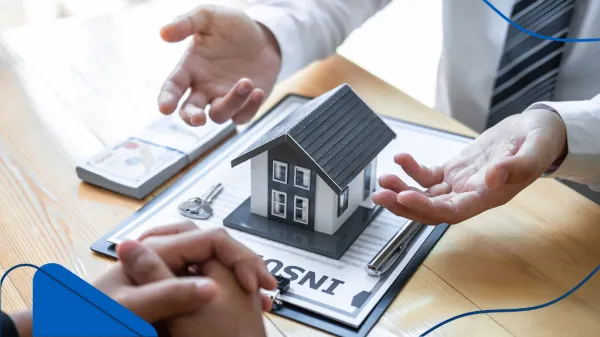 Varias personas discuten un contrato con un prototipo de casas, mientras uno de ellos explica cómo funciona la inversión en bienes raíces.