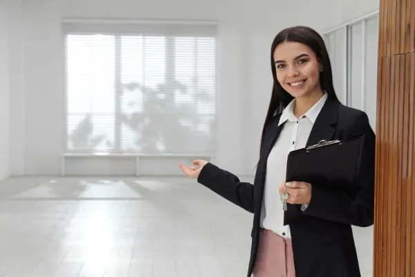 Una mujer con vestimenta formal sonriendo en un inmobiliario